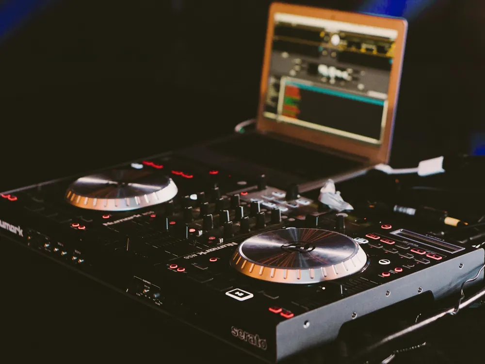 Platine DJ posée à côté d'un ordinateur portable pendant la préparation d'un set