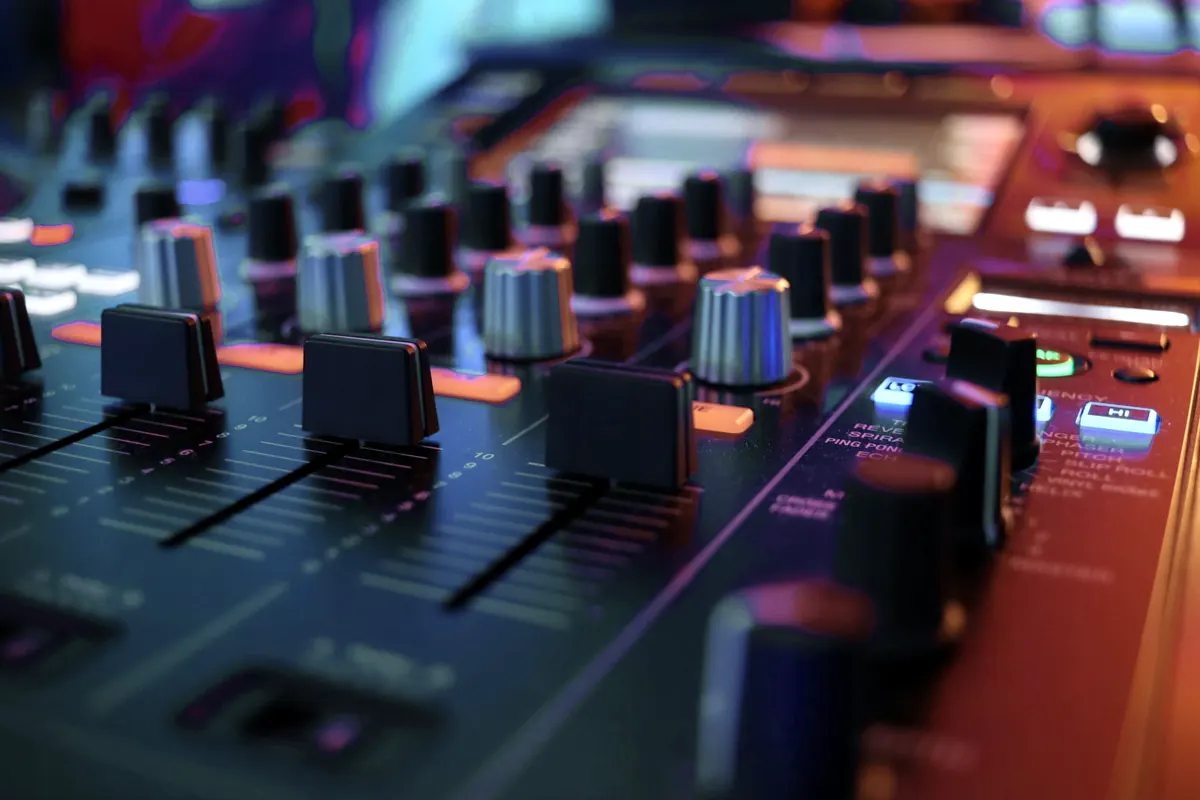Table de mixage et faders sous une lumière basse, dans la salle de pratique
