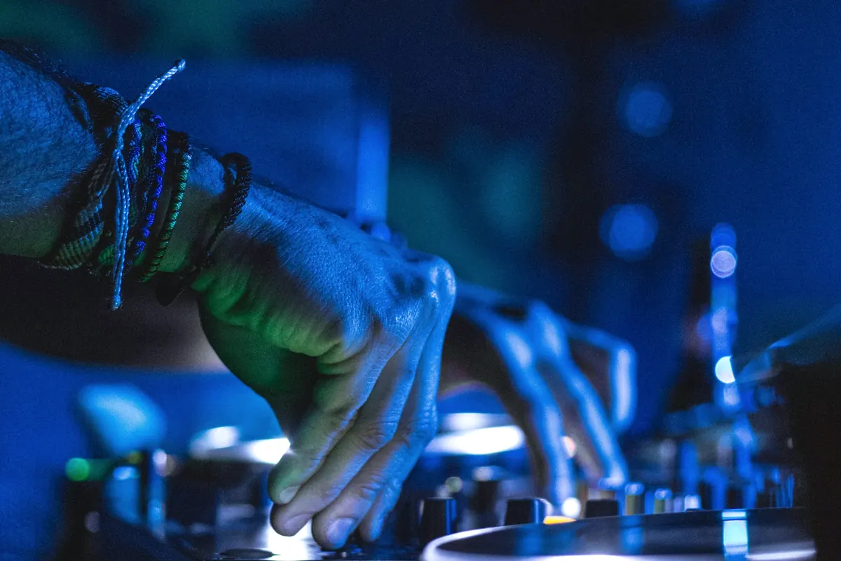Mains d'un débutant sur un contrôleur DJ pendant un cours d'initiation